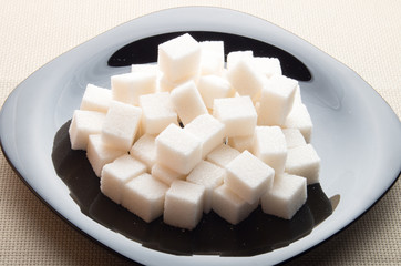 Pieces of sugar on a black plate with backlight