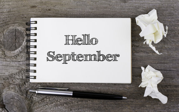 Hello September. On a wooden table notebook