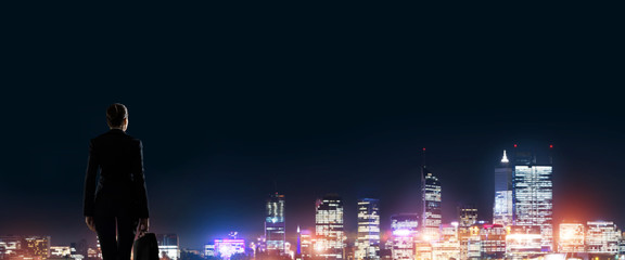 Businesswoman viewing night glowing city