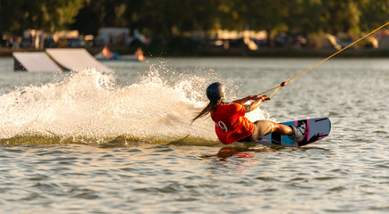 Young active woman on the wakeboard in cable park Merkur, Nove Mlyny, South Moravia, Czech Republic - obrazy, fototapety, plakaty