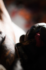 Tattoo machine needles on human skin. Close up