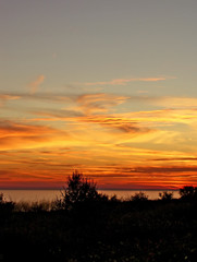 Fototapeta premium Beautiful orange and gold sunset over a lake, with space for text.
