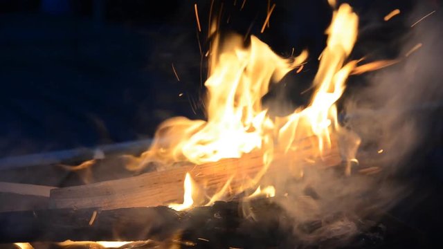 The firewood burning in a brazier closeup in the night. 