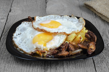 Fried eggs with potatoes and mushrooms
