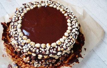 Icing a vegan chocolate and hazelnut cake on wax paper