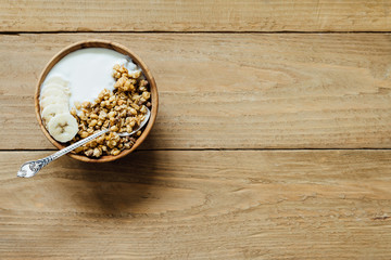 Fototapeta na wymiar Homemade oatmeal granola with yogurt in wooden bowl