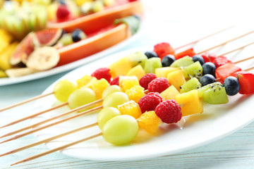 Fresh fruit on skewers on a white wooden table