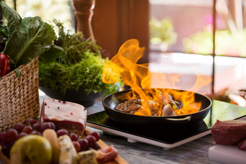 Flames in pan. Meat and garlic being fried. Recipe of flambe steak. Hot and spicy.