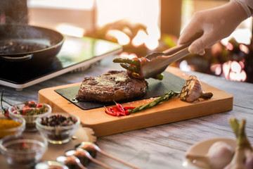 Tongs hold fried asparagus. Roasted garlic and meat. You should try ribeye steak. True mastery of chef.
