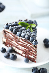 Tasty piece of cake with blueberries on wooden table