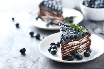 Tasty piece of cake with blueberries on wooden table