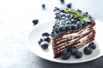 Tasty piece of cake with blueberries on wooden table
