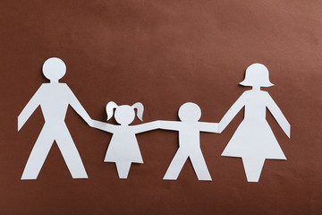 Happy paper family on brown background