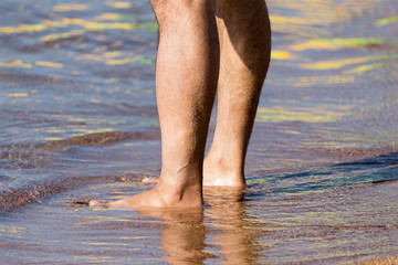 Men's legs on the beach