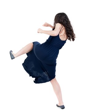 skinny woman funny fights waving his arms and legs. dark curly girl in blue evening dress kicks.