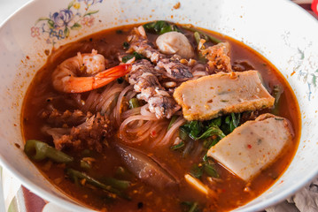 Rice noddle with seafood topping in red spicy soup