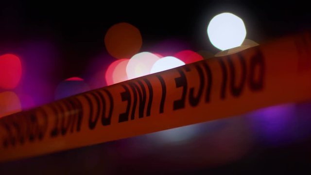 Police Line with flashing lights in background