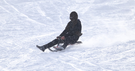 Fototapeta na wymiar man sledding in the snow
