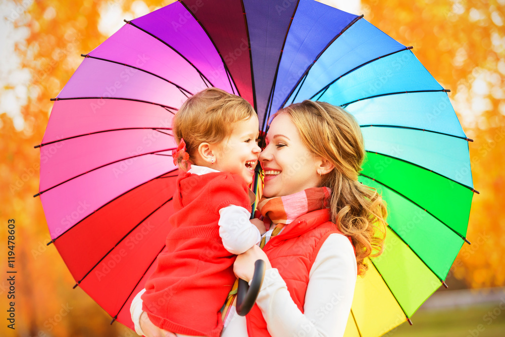 Wall mural Happy family mum and child daughter with rainbow colored umbrell