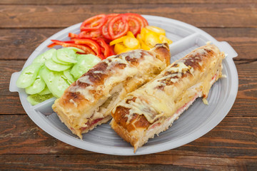Obraz na płótnie Canvas Tasty sandwich with ham, melted cheese and vegetables