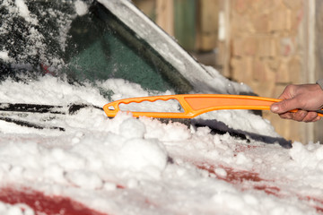 scraping snow from car winter