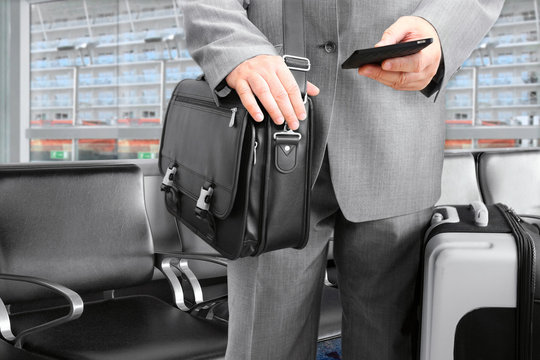 Traveling Businessman with His Luggage Using Phone at the cruise terminal