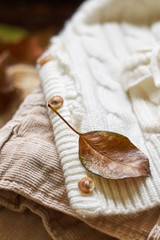 Stack of fall clothes for women on wooden background