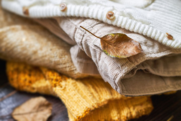 Stack of fall clothes for women on wooden background