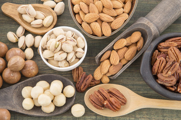 Group of nuts on wooden table. Almonds, pistachios, macadamia and pecan nut