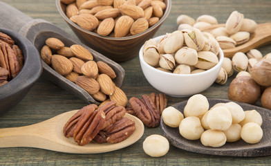 Group of nuts on wooden table. Almonds, pistachios, macadamia and pecan nut