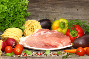 raw meat, pasta and vegetables on the table