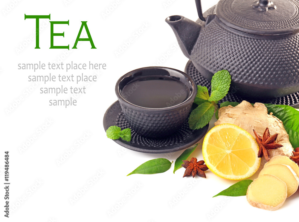 Wall mural cup of tea with teapot, lemon and ginger slices on white background. space for text.