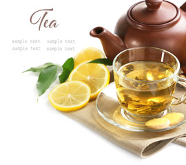 Glass cup of tea with teapot and lemon slices on white background. Space for text.