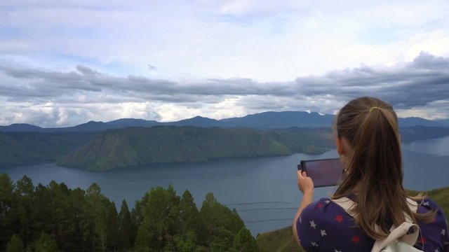 Female traveler taking photo of Toba lake in North Sumatra