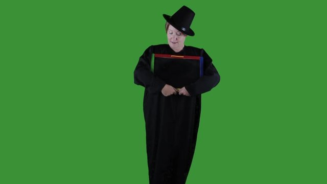 Woman dresses as pilgrim for  Thanksgiving holding blank chalkboard sign against green background.