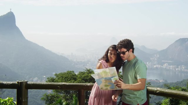 Young multiracial couple using a map