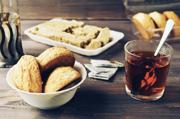 cookies, halvah, a cup of tea on a wooden table