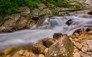 Water flows over rocks in a little waterfall.
