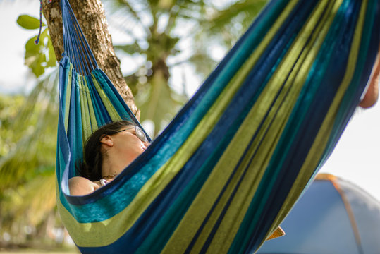 Woman Taking A Nap On A Hammock In The Beach