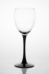 Naklejka premium Empty glass with a black stem with reflection