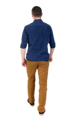 Back view of going handsome man. walking young guy . man in a blue shirt with the sleeves rolled out into the distance