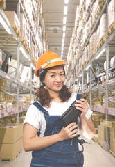 asian beautiful smiling female craftsman with electric drill on warehouse background