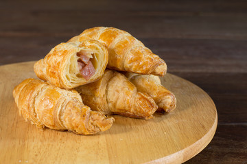Ham and cheese croissant on cutting board