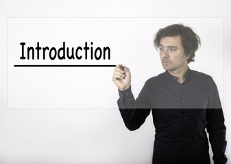 Introduction. Businessman writing with black marker on visual sc