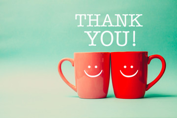 Thank you word withTwo cups of coffee and stand together with sm