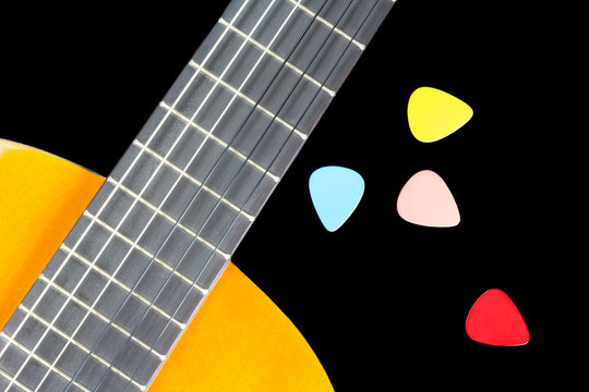 colorful picks on guitar fingerboard isolated