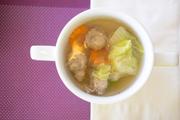 clear soup with pork in white bowl