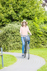 Full length portrait of a happy young woman with her vintage bike in the park