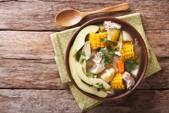Traditional Colombian ajiaco soup close up in a bowl. horizontal top view
