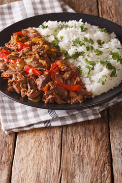 Mexican food ropa vieja: beef stew in tomato sauce with vegetables and rice. vertical

